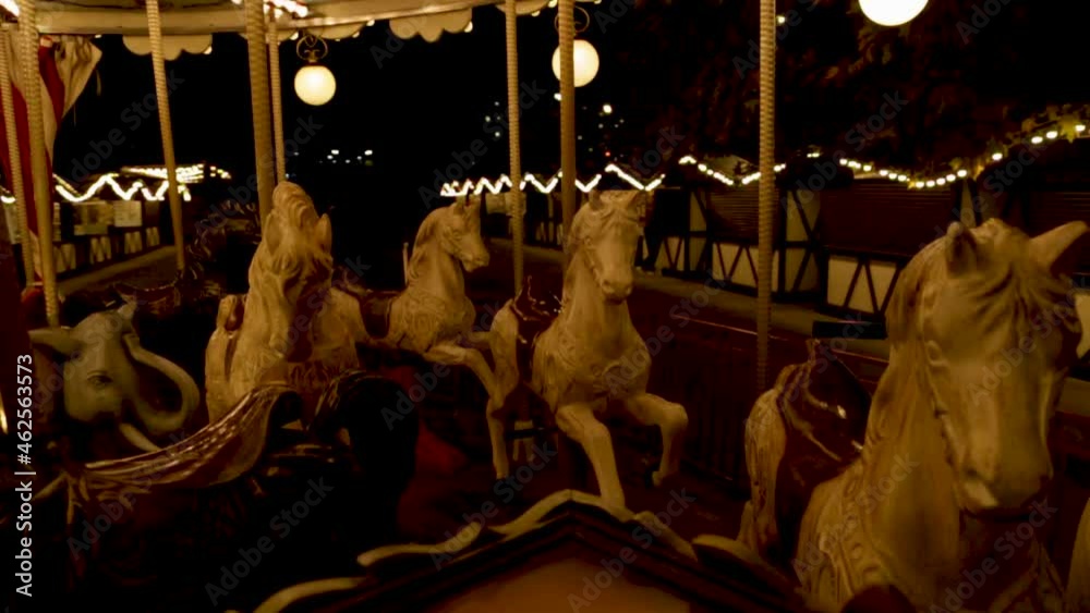 A spinning carousel with horses and elephants that rise and fall, at nightfall. High quality HD footage