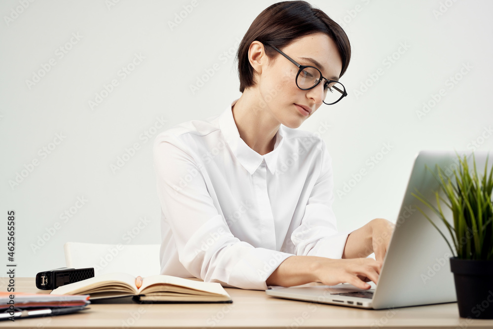 Businesswoman at the desk with glasses self-confidence light background Businesswoman at the desk with glasses self-confidence light background