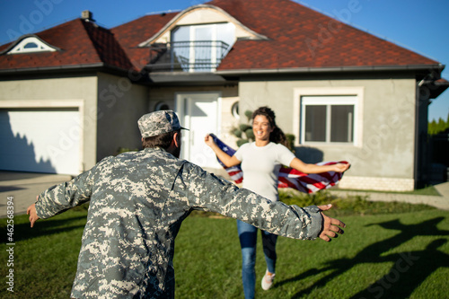 Canvastavla Soldier in uniform coming home and his lovely wife with American flag running into his arms celebrating reunion