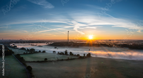 Sunrise and the first rays of sunshine over the fog-covered Ruhr meadows in Duisburg, Germany photo