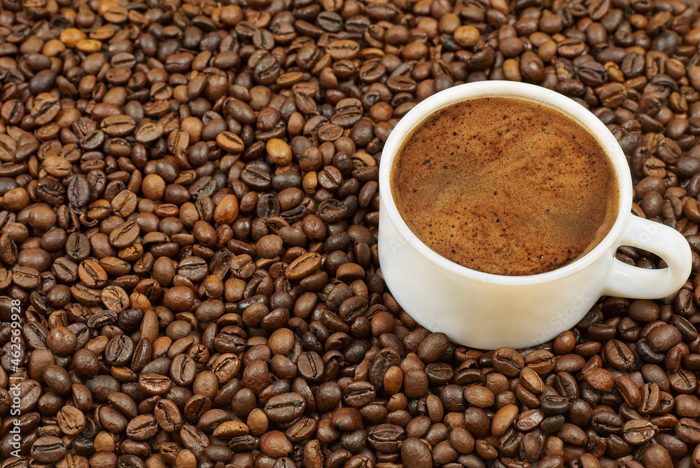 Cup of coffee on the background of roasted coffee beans. Cup of coffee on the background of roasted coffee beans.