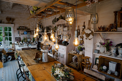 Beautiful arrangement of wooden decor and ceramic decoration in a shop for indoor  outdoor and garden. Light bulb as fairy lights.