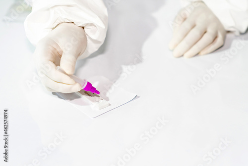 Medical technicians drop samples on antigen test kit to detect covid-19.