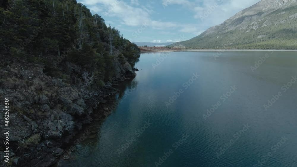 Rocky lake shore with magic forest, trees reflecting in the water. Aerial FPV drone Footage Rocky lake shore with magic forest, trees reflecting in the water. Aerial FPV drone Footage