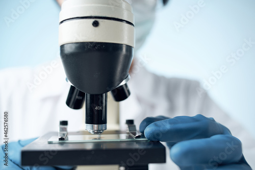 scientist sitting at the table microscope research biotechnology light background