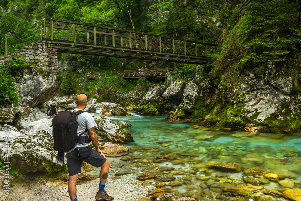 Tolmin Gorge Canyon, Soca Valley Slovenia. Adventure Hiker Looking at Suspension Bridge Tolmin Gorge Canyon, Soca Valley Slovenia. Adventure Hiker Looking at Suspension Bridge