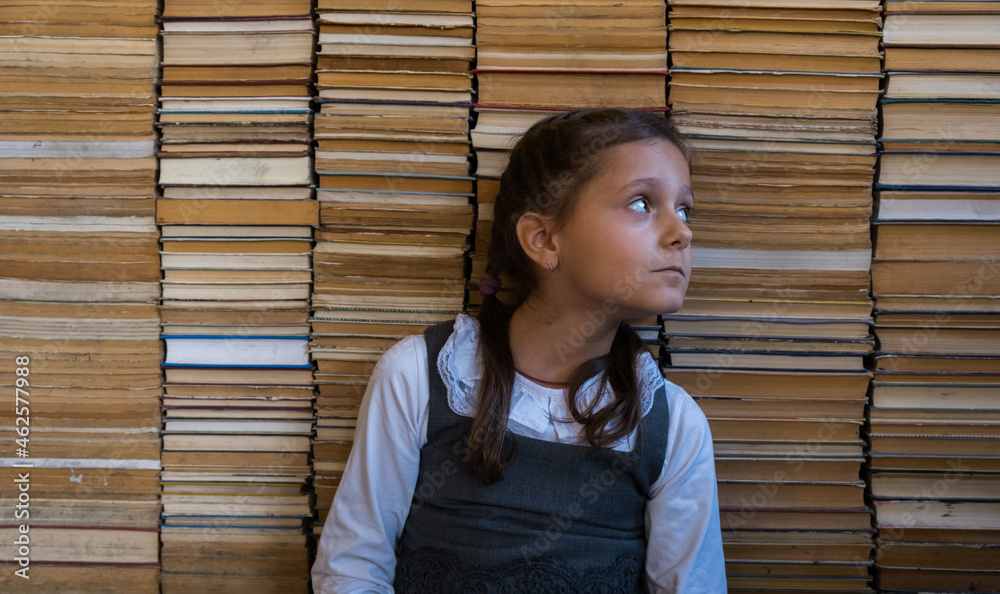 Reading Addiction Curious cute preschool kid girl sitting with a book, on books ...