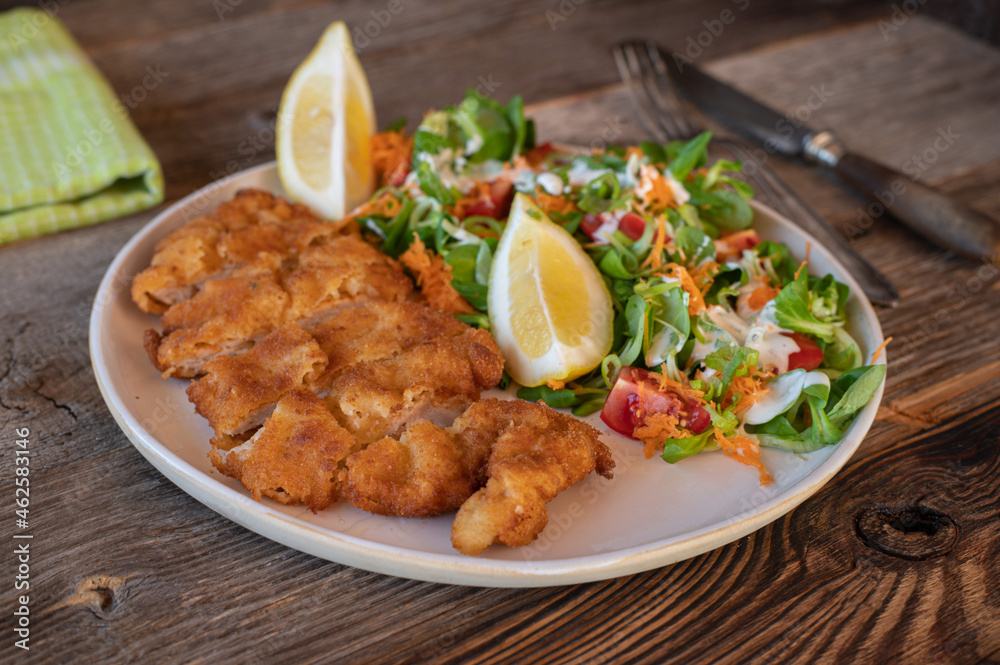 Pork schnitzel with mixed salad on a plate