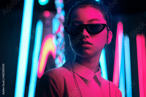 Teenage asian girl in sun glasses in neon light