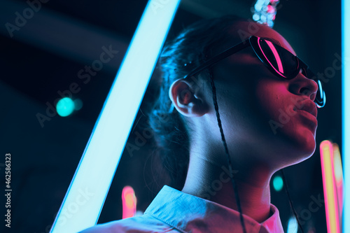 Teenage asian girl in sun glasses in neon light