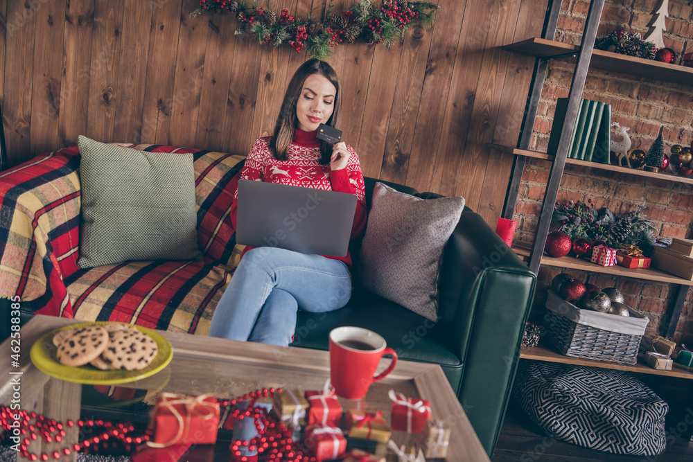 Obraz premium Photo of thoughtful lady hold debit card search pc network prepare buy noel presents in decorated x-mas home indoors