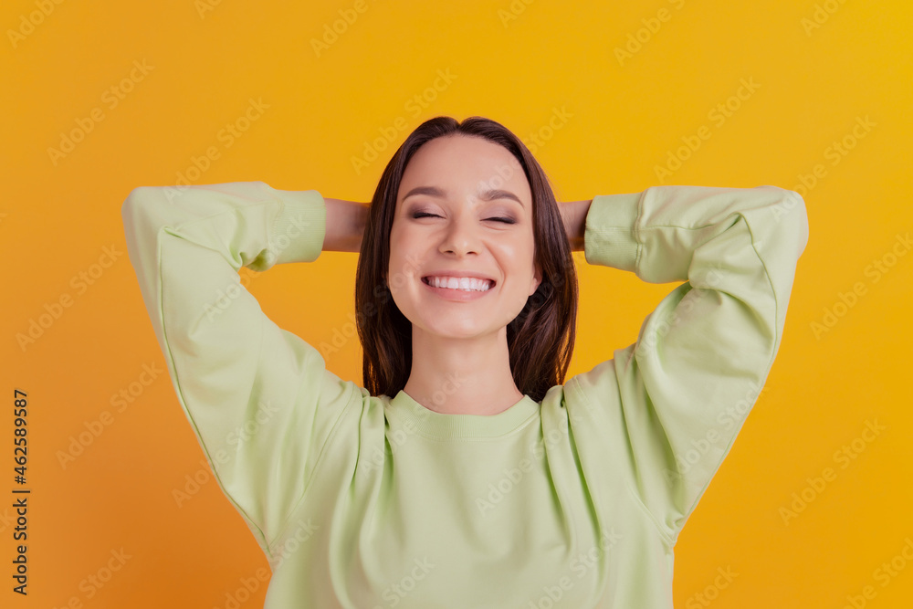 Top above hight angle view photo of young girl hands behind head rest dream sleep relax isolated on yellow color background Top above hight angle view photo of young girl hands behind head rest dream sleep relax isolated on yellow color background