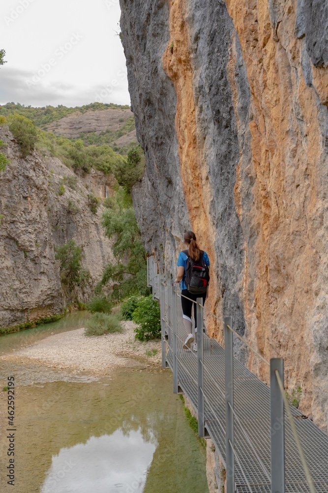 Young woman doing sports by the mountain, iron footbridges