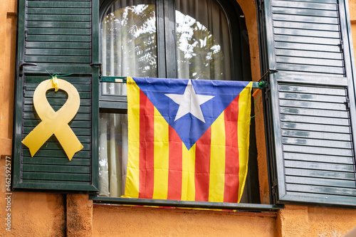 Catalan independence flag and yellow ribbon hanging from a window demanding the independence of Catalonia and the freedom of the imprisoned politicians photo