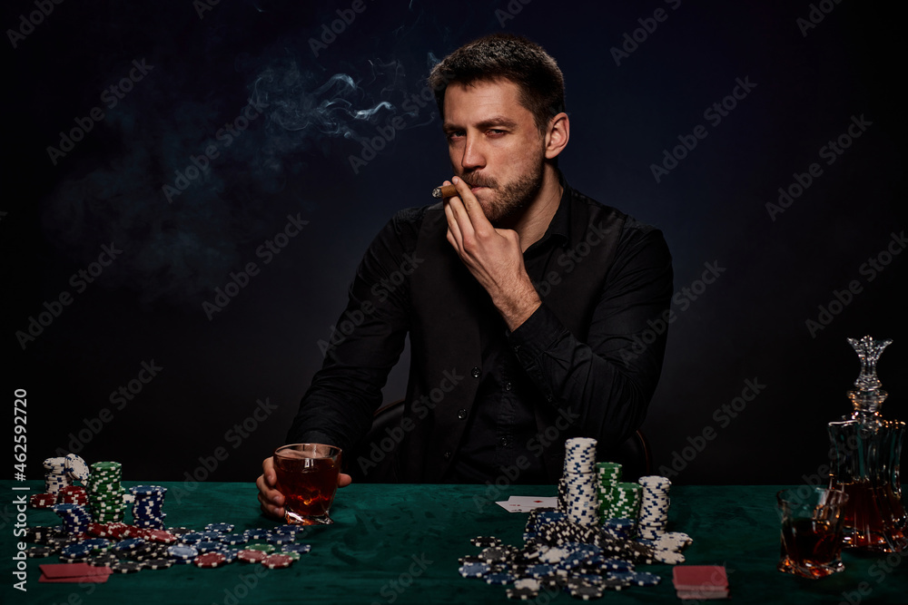 Bearded casino player man playing poker on green table