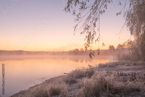 amazing sunrise landscape with morning fog in the forest lake reflected water autumn scenic view of lake in foggy weather  cold fall colors. wanderlust