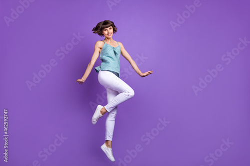 Full length body size view of attractive cheerful girl jumping having fun isolated over bright violet purple color background