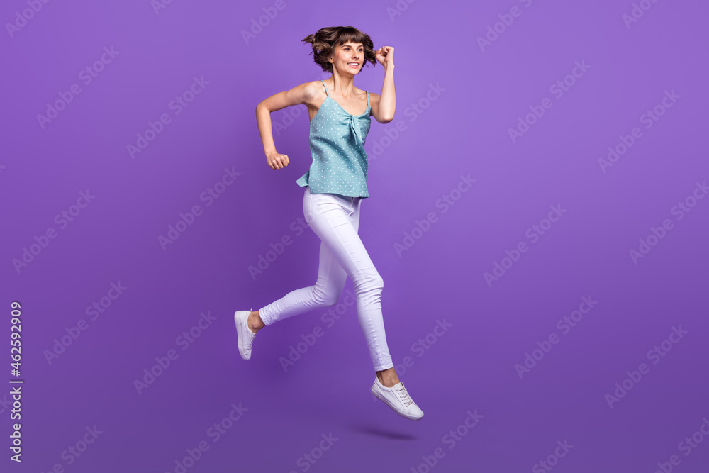 Full length body size view of lovely cheerful girl jumping jogging isolated over bright violet purple color background