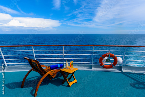 Sun loungers to enjoy the ocean views, with a cocktail table next to it on the ship's deck.