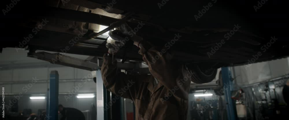 custom made wallpaper toronto digitalCU portrait of Caucasian female mechanic repairing a car in a workshop, working under car bottom. Shot with 2x anamorphic lens