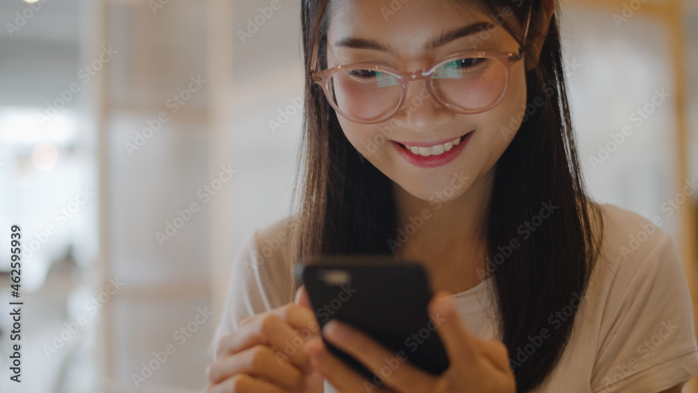 Freelance Asian women using mobile phone at office. Young Japanese Asia Girl using smartphone checking social media on the internet on the table at workplace concept. Freelance Asian women using mobile phone at office. Young Japanese Asia Girl using smartphone checking social media on the internet on the table at workplace concept.