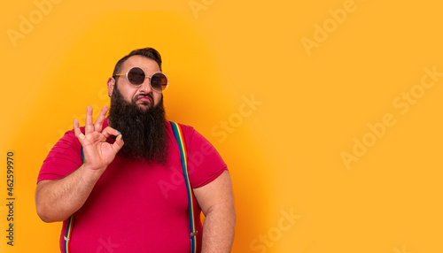 Big funny bearded man wearing sunglasses and doing a perfect hands sign