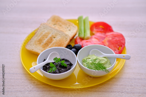 Healthy breakfast with bread guacamole olive paste tomatoes and cucumbers 