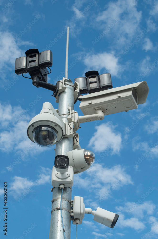 Pillar with different security cameras and motion sensors in blue sky