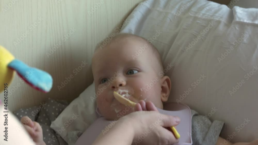 Family with little child traveling by train, mother feeds baby from a jar on seat by window in a compartment train. High quality 4k footage Family with little child traveling by train, mother feeds baby from a jar on seat by window in a compartment train. High quality 4k footage