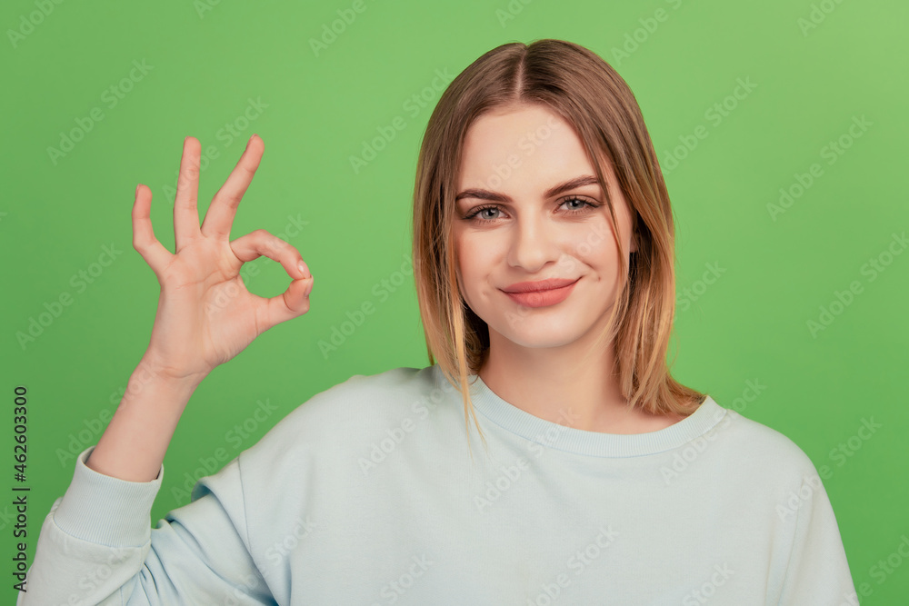 Close-up portrait of nice girl showing ok-sign advert great cool isolated over green color background Close-up portrait of nice girl showing ok-sign advert great cool isolated over green color background