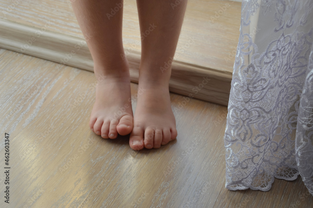 small bare children's feet on the light floor. background for the design. small bare children's feet on the light floor. background for the design.