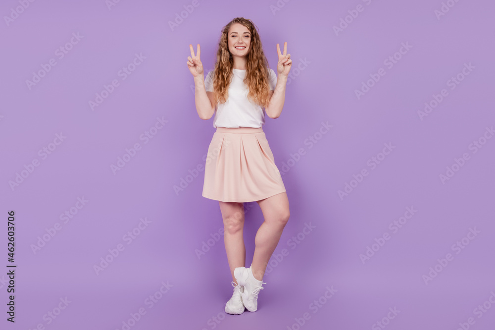 Portrait of attractive cheerful girl showing double v-sign having fun isolated over violet purple color background