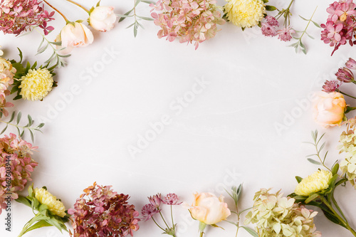 Autumn flowers composition. Frame made of pink rose, hydrangea flowers on white gray background. Flat lay