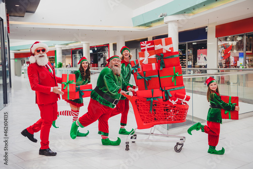 Portrait of attractive cheerful funny group friends company elfs carrying giftboxes bargain eve tradition at mall indoors