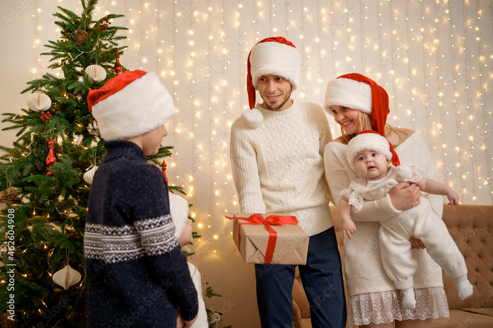 Fototapeta premium Christmas Family. Happiness. Portrait of dad, mom two daughters and son having good times together
