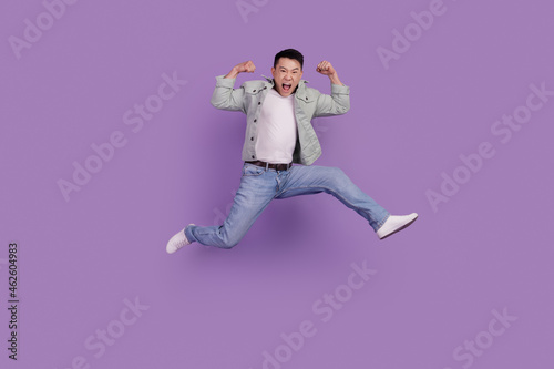 Photo of crazy active chinese man jump have fun isolated violet color background