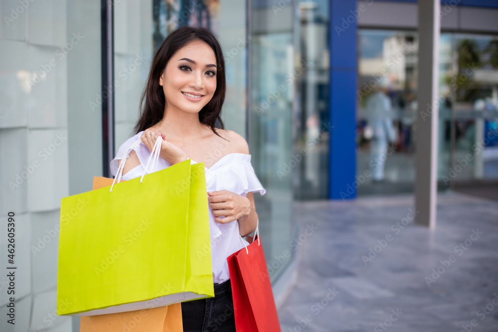 Portrait Asian beautiful happy young woman smiling cheerful and she holding shopping bags Portrait Asian beautiful happy young woman smiling cheerful and she holding shopping bags