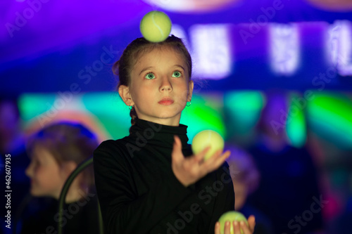 Little girl juggles balls. The circus art of juggling.