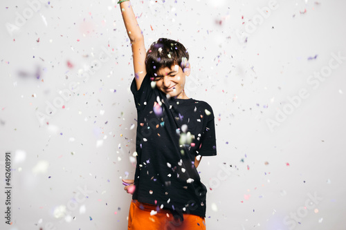 Portrait of a ten years old boy throwing confetti to the air