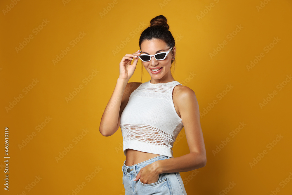 Beautiful woman in sunglasses on yellow background Beautiful woman in sunglasses on yellow background