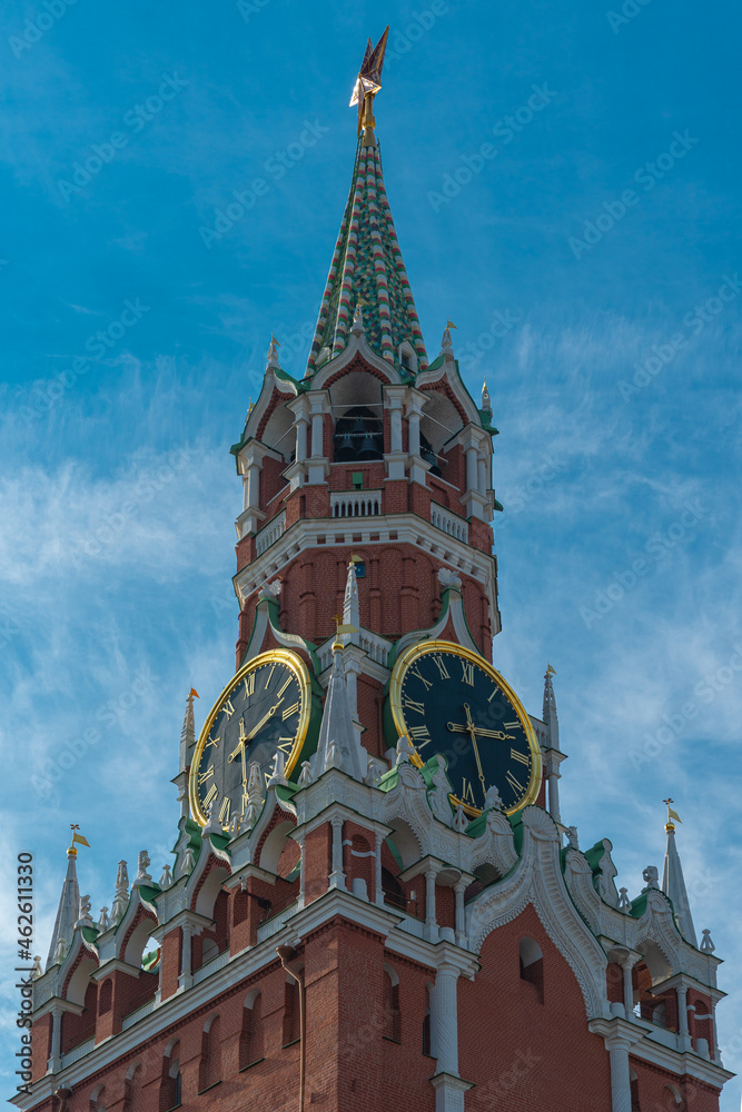 Obraz premium View of the Kremlin tower with chimes against a blue sky with light clouds, vertical Moscow photo