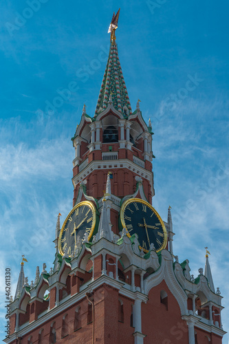 View of the Kremlin tower with chimes against a blue sky with light clouds, vertical Moscow photo