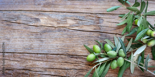 Olive branch on wooden rustic background . Fresh and Healthy organic olive fruits border design with copy space for your text. 