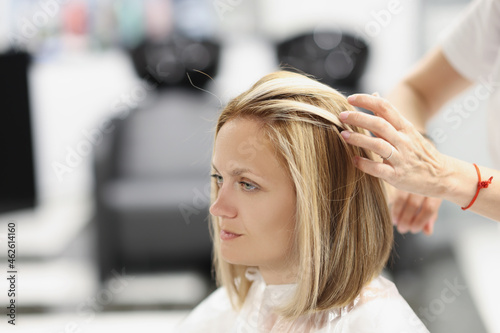 Foto Hairdresser making hair styling to woman client in beauty salon