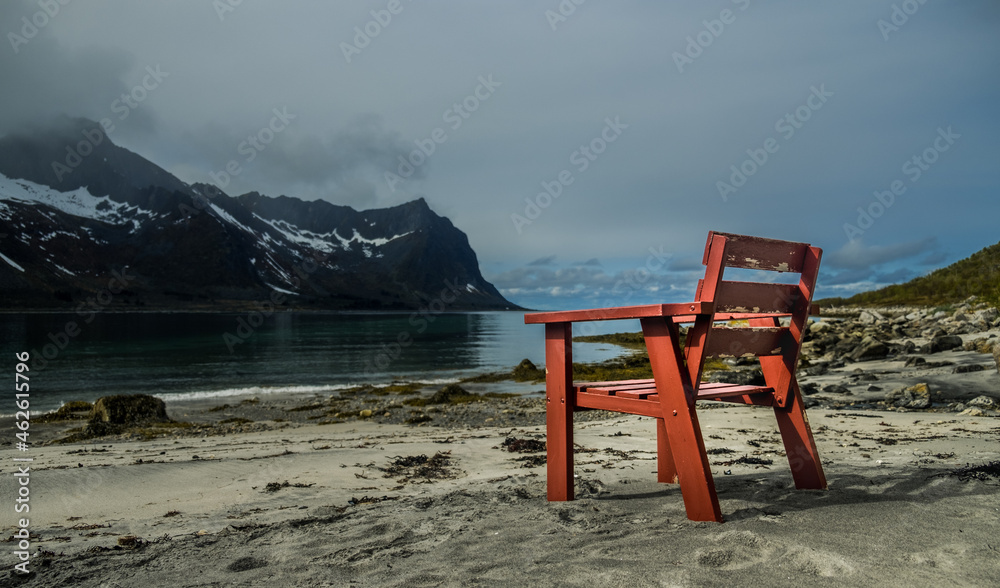 Red chair on the beach of a Norwegian fjord
