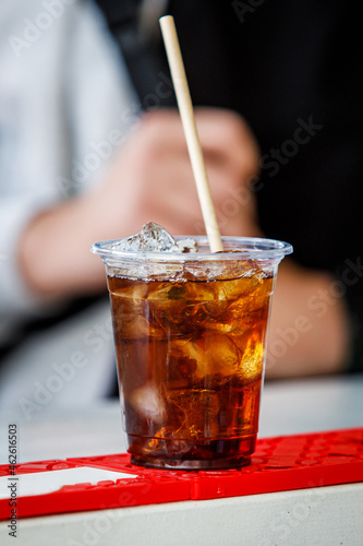 Фотография Cocktail with cola and ice in a plastic glass.