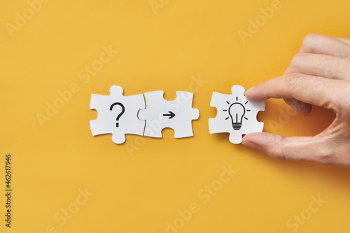 A question mark and a light bulb on the puzzles. Finding answers to questions and solving problems