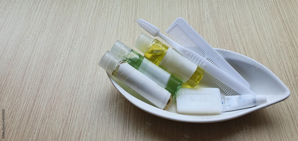A small kit set of toiletries perfect for travel: soap, shampoo, conditioner, shower gel, comb, shower cap, white toothbrush, toothpaste, white comb and body lotion.All are small were placed on a tray A small kit set of toiletries perfect for travel: soap, shampoo, conditioner, shower gel, comb, shower cap, white toothbrush, toothpaste, white comb and body lotion.All are small were placed on a tray