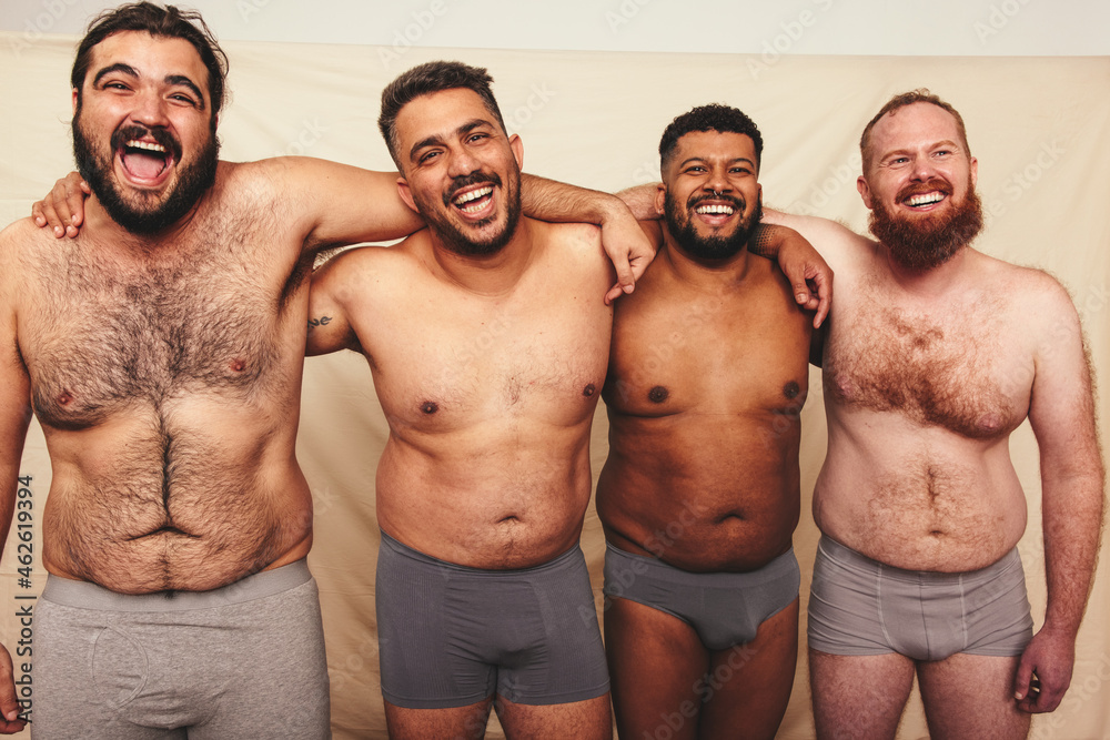 Studio shot of shirtless men embracing each other Studio shot of shirtless men embracing each other