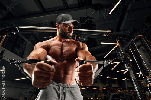 bald brutal sexy strong bodybuilder athletic fitness man pumping up abs muscles workout bodybuilding concept background photo